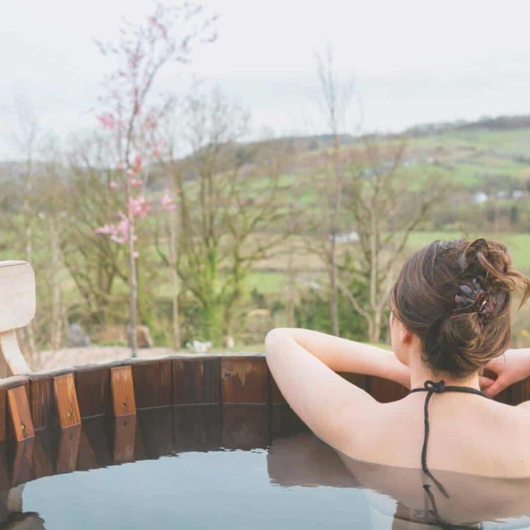 a woman soaking in a wooden hot tub