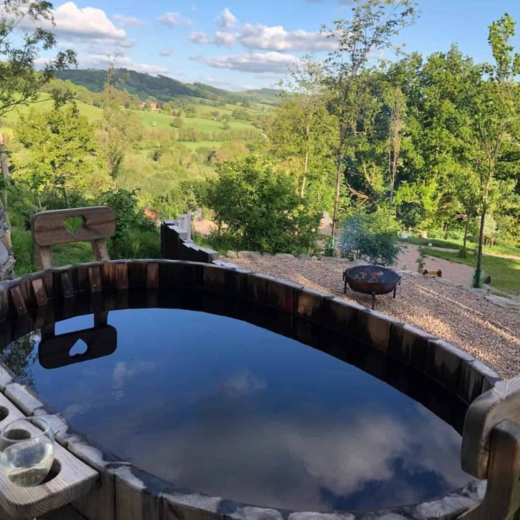 Private wood-fired hot tub with countryside views at the luxury safari tent, perfect for romantic breaks.