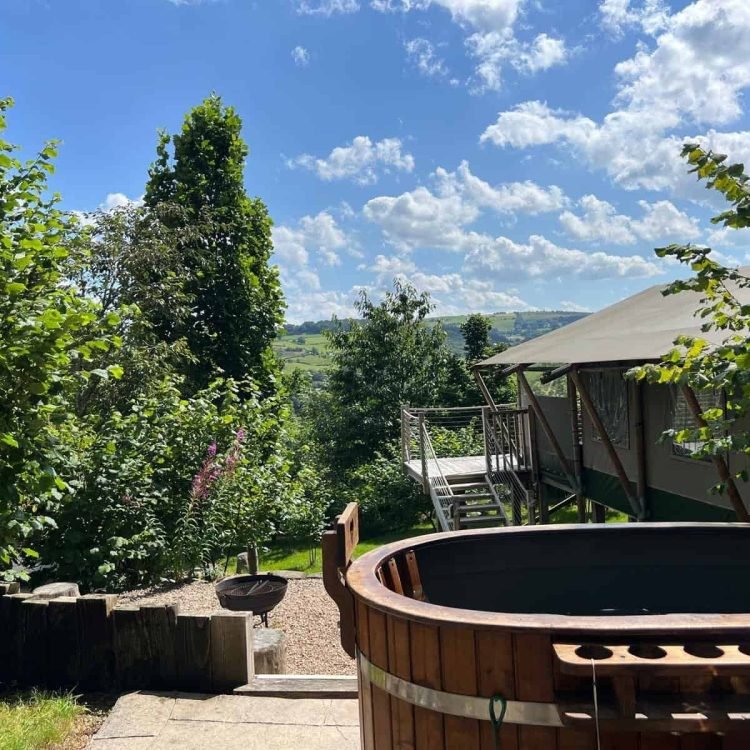 Private wood-fired hot tub outside the safari tent with views over the lush Welsh countryside at Oaklands.