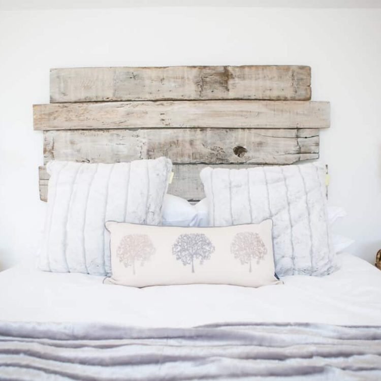 a bedroom with a reclaimed wood headboard