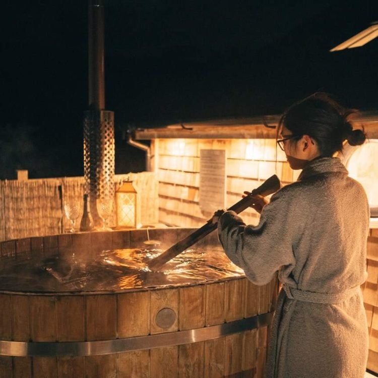 a women in a towel robe by a hot tub at night