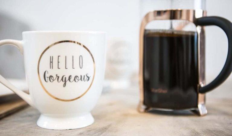 a cup of coffee and a mug with a slogan