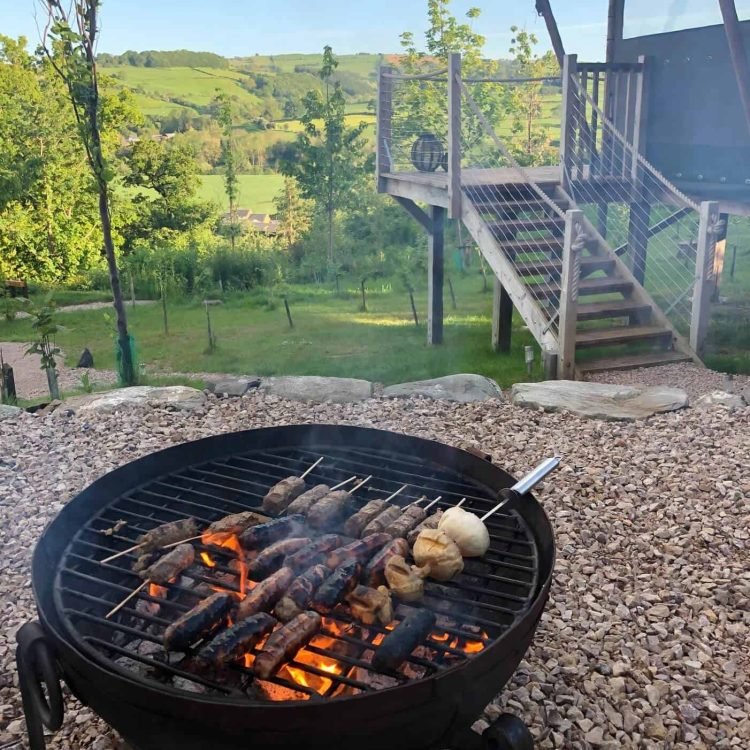 a bbq with meat skewers by a safari tent