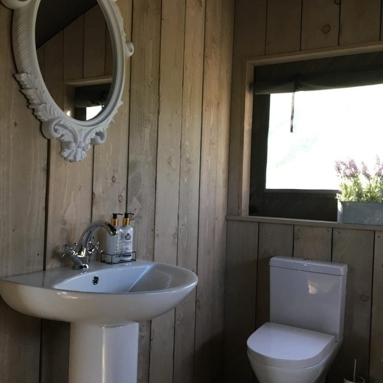 Bathroom with modern sink and toilet inside the luxury safari tents at Oaklands Glamping Wales.